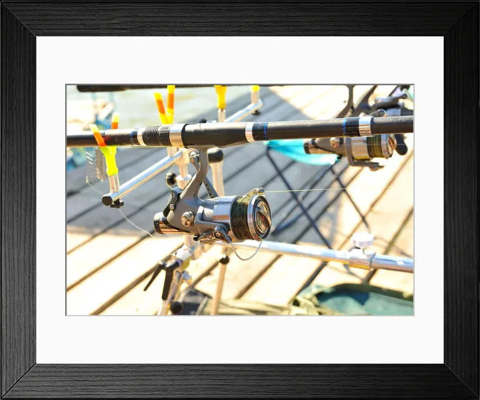 Framed Print : Coil rod, which is mounted on the jetty for fishing on a sunny day Framed Print : Coil rod, which is mounted on the jetty for fishing on a sunny day