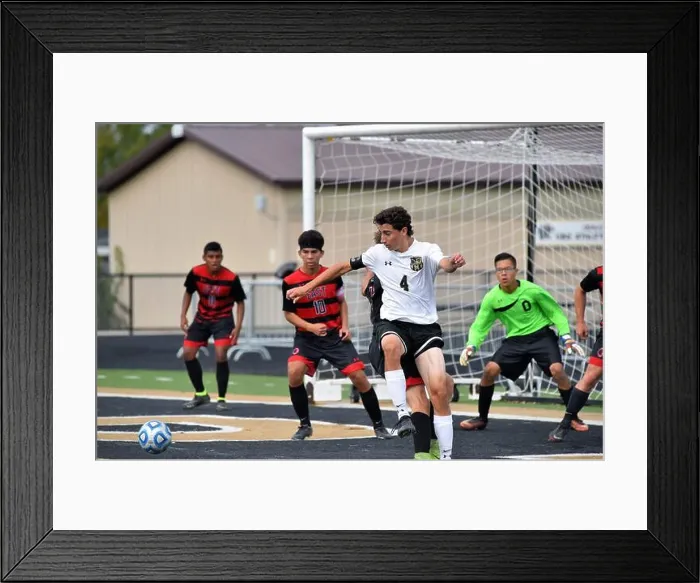 Framed Print : Player attempting to control a corner kick in front of the opposing goal