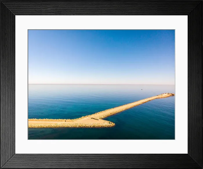 Framed Print : Aerial drone view of a breakwater and a lighthouse in Denia port, Spain Framed Print : Aerial drone view of a breakwater and a lighthouse in Denia port, Spain