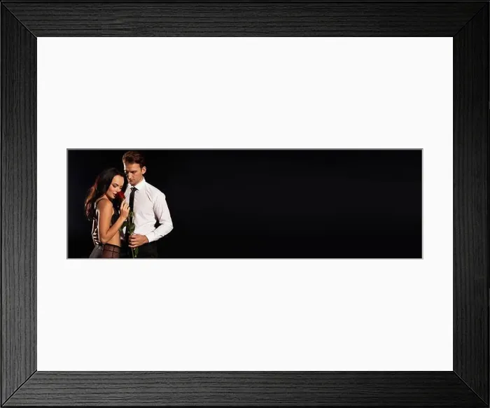 Framed Print : A couple shares a tender embrace, showcasing love with a rose in a dimly lit space Framed Print : A couple shares a tender embrace, showcasing love with a rose in a dimly lit space