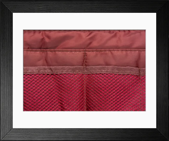 Framed Print : Burgundy travel bag organizer with pockets from mesh fabric, close-up Framed Print : Burgundy travel bag organizer with pockets from mesh fabric, close-up