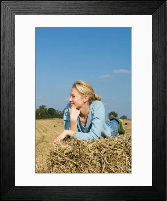 Framed Print : Woman lying on hay bale Framed Print : Woman lying on hay bale