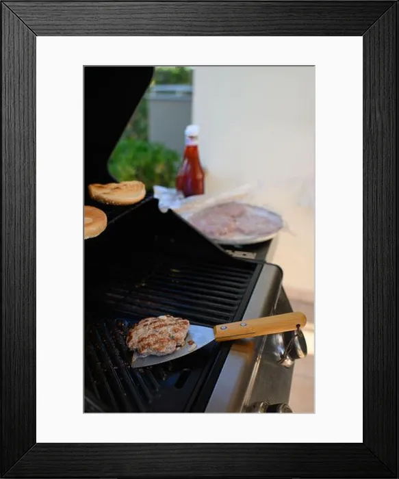 Framed Print : A man is standing near the grill on a terrace, grilling meat Framed Print : A man is standing near the grill on a terrace, grilling meat