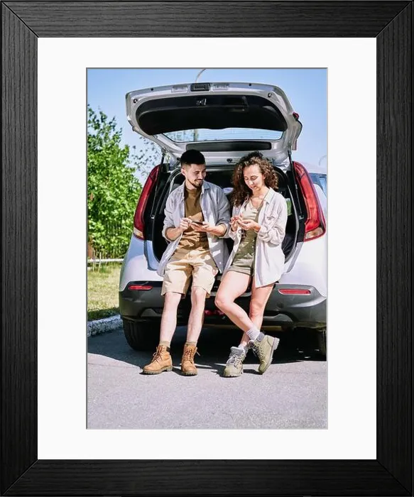 Framed Print : Positive active young hikers in boots leaning on car trunk and discussing hiking route using phone apps Framed Print : Positive active young hikers in boots leaning on car trunk and discussing hiking route using phone apps