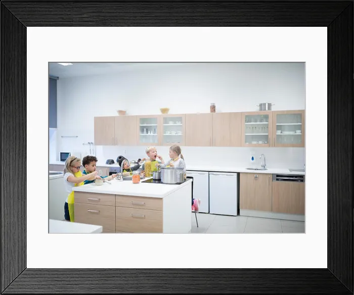 Framed Print : Pupils cooking together in cooking class