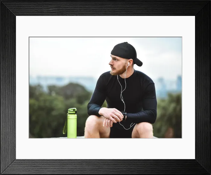 Framed Print : Muscular bearded athlete checking burned calories on smart watch after good workout session on city Framed Print : Muscular bearded athlete checking burned calories on smart watch after good workout session on city