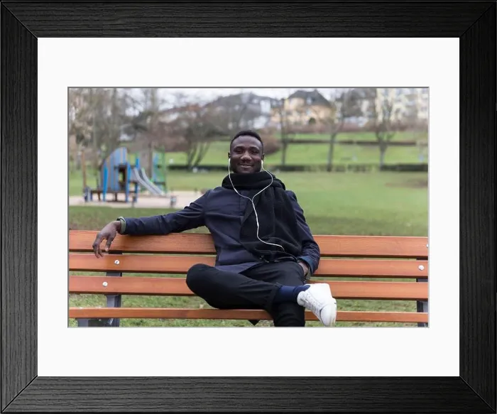 Framed Print : Young Black Man Leaning Back on Park Bench Confidently Framed Print : Young Black Man Leaning Back on Park Bench Confidently