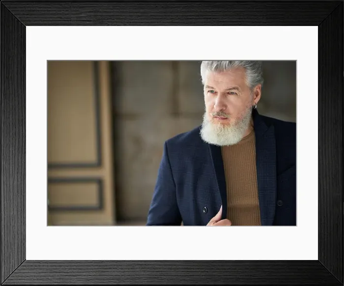 Framed Print : Portrait of stylish handsome mature man in casual clothes looking away while posing indoors Framed Print : Portrait of stylish handsome mature man in casual clothes looking away while posing indoors