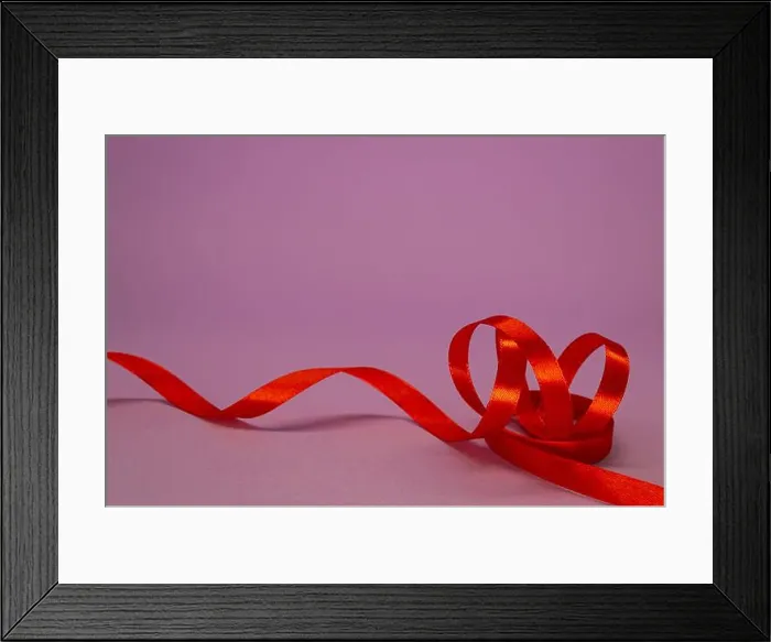 Framed Print : Red satin ribbon curls on a lilac background, free space Framed Print : Red satin ribbon curls on a lilac background, free space