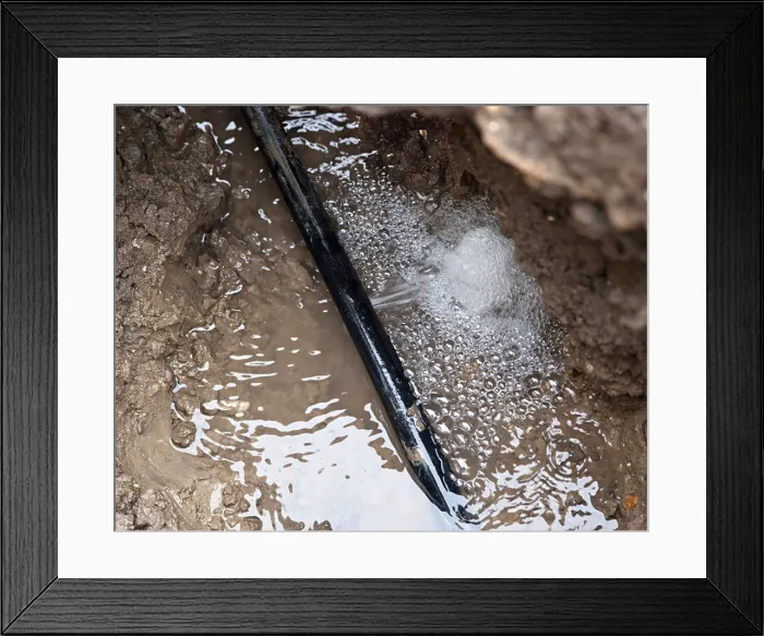 Framed Print : water leak in a polythene pipe underground in a trench before repairing Framed Print : water leak in a polythene pipe underground in a trench before repairing