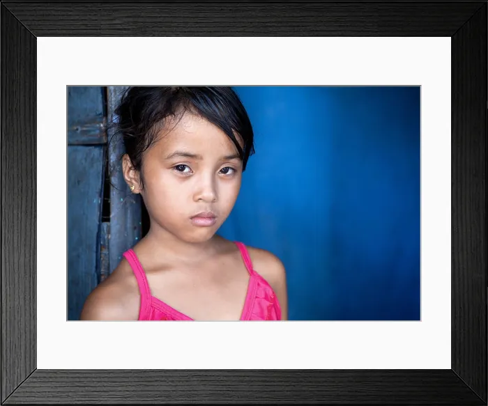 Framed Print : Young Filipina girl 8 years old with sad and somber expression over blue, poverty in the Philippines Framed Print : Young Filipina girl 8 years old with sad and somber expression over blue, poverty in the Philippines