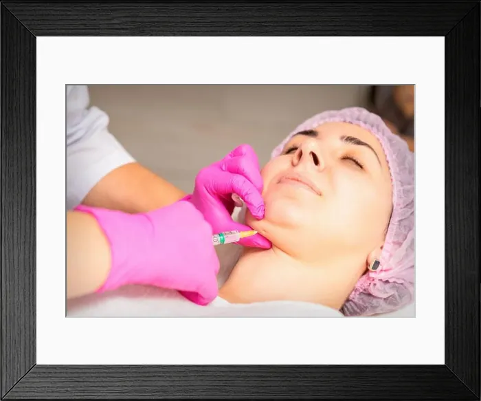 Framed Print : The cosmetologist makes lipolytic injection on the chin of a young woman against the double chin in a beauty salon Framed Print : The cosmetologist makes lipolytic injection on the chin of a young woman against the double chin in a beauty salon