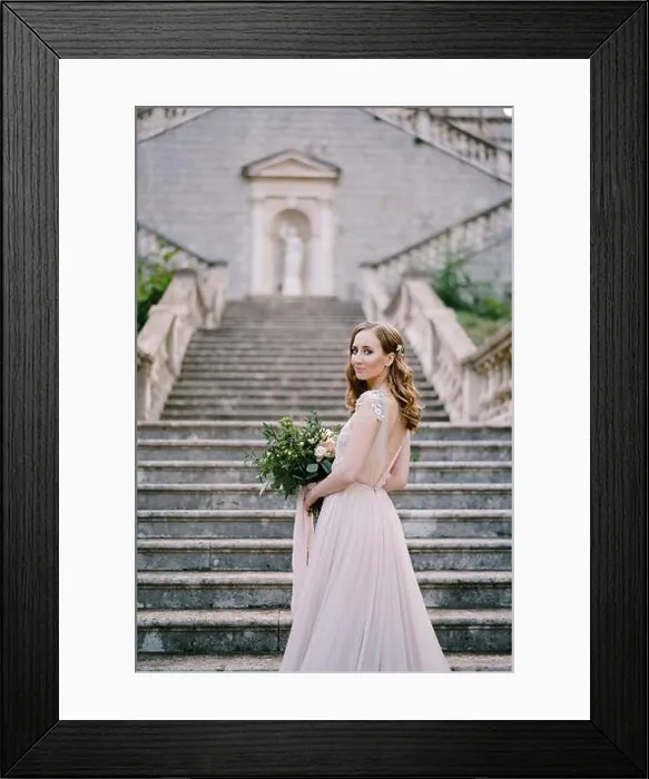 Framed Print : Bride stands half-turned on the stone steps near the old building Framed Print : Bride stands half-turned on the stone steps near the old building