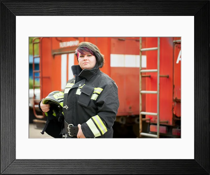 Framed Print : Image of brunette firefighter standing next to firefighters car on street Framed Print : Image of brunette firefighter standing next to firefighters car on street
