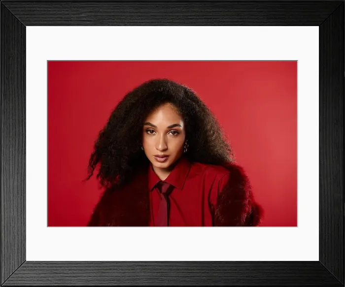 Framed Print : A stunning Black woman in a trendy autumn outfit poses confidently against a vivid backdrop Framed Print : A stunning Black woman in a trendy autumn outfit poses confidently against a vivid backdrop