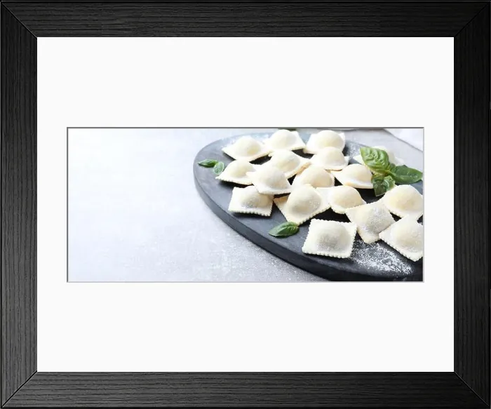 Framed Print : Homemade uncooked ravioli and basil on grey table Framed Print : Homemade uncooked ravioli and basil on grey table