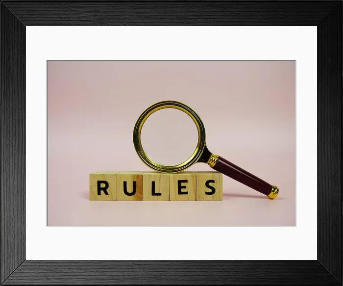 Framed Print : Rules with wooden blocks alphabet letters and Magnifying glass on pink background Framed Print : Rules with wooden blocks alphabet letters and Magnifying glass on pink background