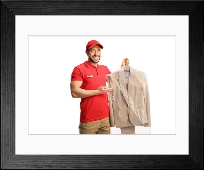 Framed Print : Male worker showing a suit from dry cleaners isolated on a white background Framed Print : Male worker showing a suit from dry cleaners isolated on a white background