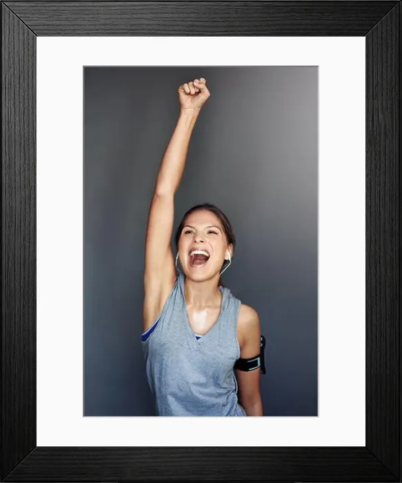 Framed Print : I did it. a sporty young woman celebrating a victory against a gray background Framed Print : I did it. a sporty young woman celebrating a victory against a gray background