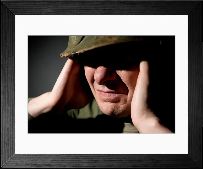 Framed Print : Close up, of Vietnam War period American soldier, with his eyes in shadow and covering his ears with his hands