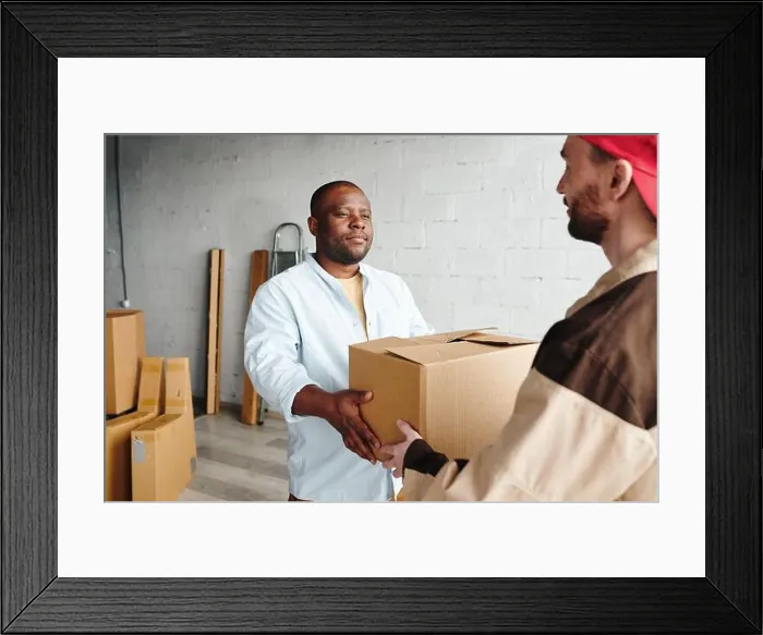 Framed Print : Young loader holding packed cardboard box Framed Print : Young loader holding packed cardboard box