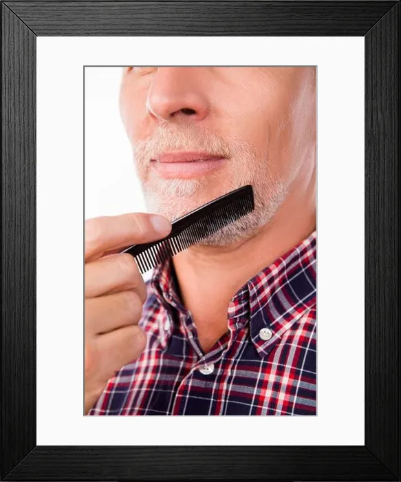 Framed Print : Closeup photo of an aged man combing his beard