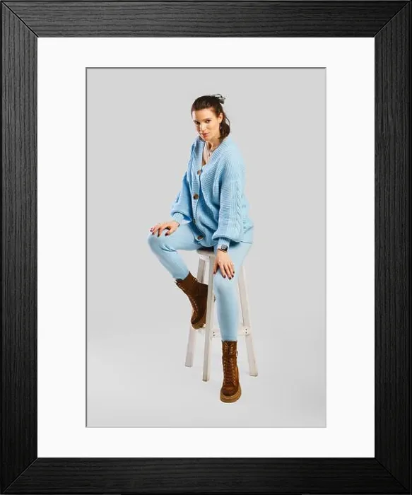 Framed Print : Full length portrait of beautiful woman in light blue warm knitted tracksuit sitting on stool over grey background Framed Print : Full length portrait of beautiful woman in light blue warm knitted tracksuit sitting on stool over grey background