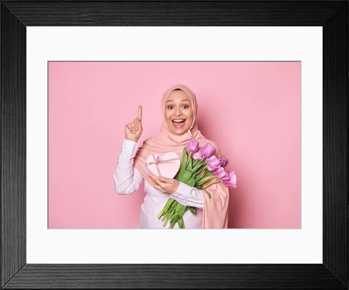 Framed Print : Happy amazed pregnant Muslim woman in pink hijab, holds a bouquet of tulips and gift box, points finger up at copy space Framed Print : Happy amazed pregnant Muslim woman in pink hijab, holds a bouquet of tulips and gift box, points finger up at copy space