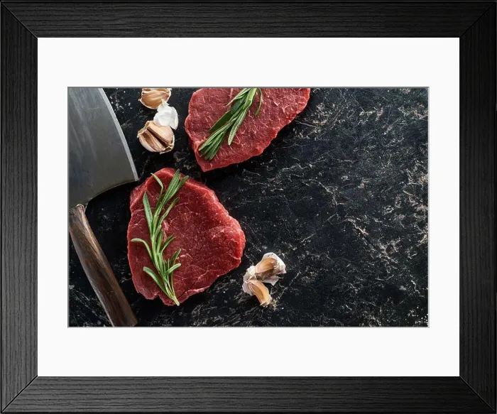 Framed Print : top view of raw beef steaks with rosemary twigs and garlic cloves near sharp knife on black marble surface Framed Print : top view of raw beef steaks with rosemary twigs and garlic cloves near sharp knife on black marble surface