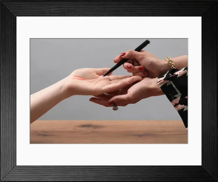 Framed Print : Fortune teller reading lines on woman's palm at wooden table, closeup. Chiromancy Framed Print : Fortune teller reading lines on woman's palm at wooden table, closeup. Chiromancy