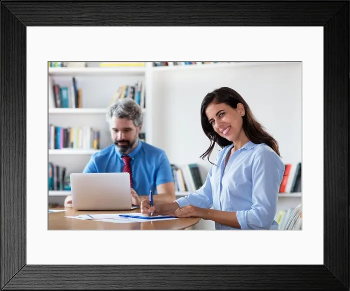 Framed Print : Laughing mexican businesswoman with colleague at desk at office of start up company Framed Print : Laughing mexican businesswoman with colleague at desk at office of start up company