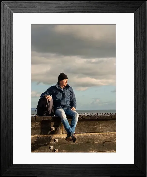 Framed Print : Guy with a backpack sitting resting enjoying the view after walking. Wearing outdoor clothes Framed Print : Guy with a backpack sitting resting enjoying the view after walking. Wearing outdoor clothes