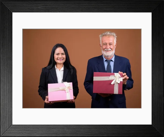 Framed Print : Mature multi-ethnic business couple against brown background Framed Print : Mature multi-ethnic business couple against brown background