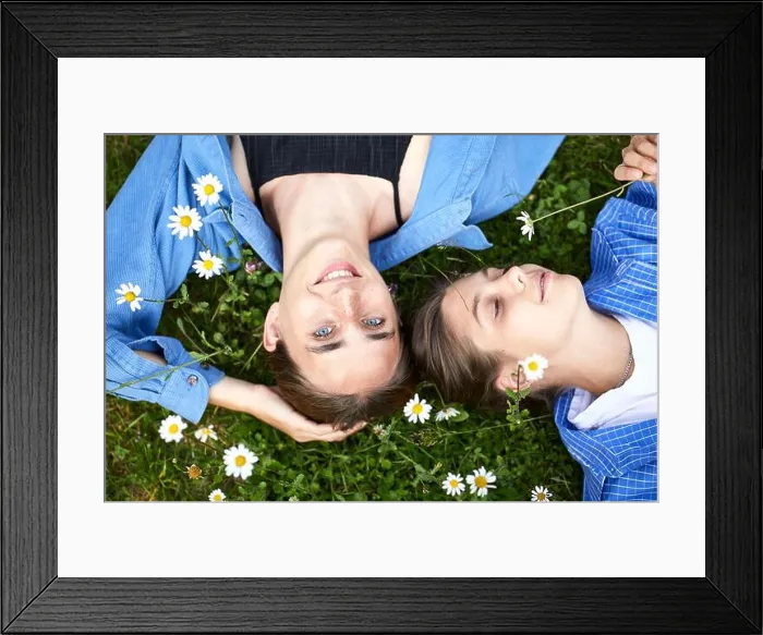 Framed Print : Close-up of female friends relaxing on grassy land in garden