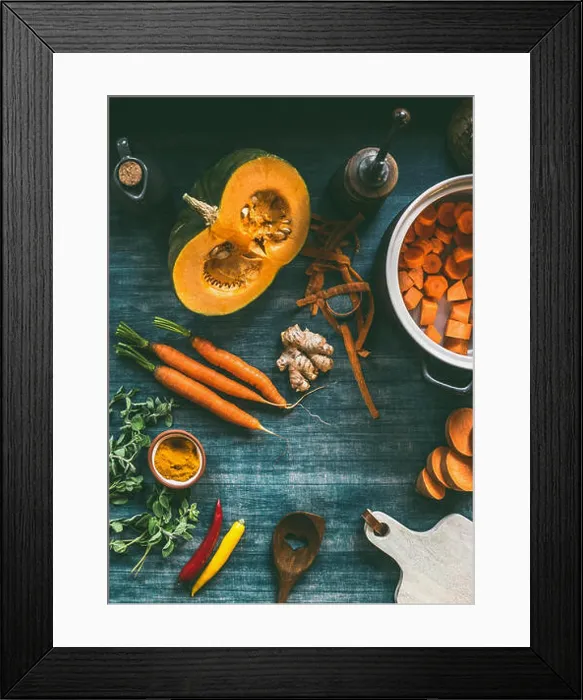 Framed Print : Cutting vegetables for pumpkin soup or vegetarian stew on kitchen table with pot Framed Print : Cutting vegetables for pumpkin soup or vegetarian stew on kitchen table with pot