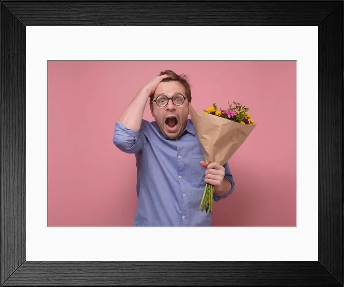 Framed Print : Young caucasian man in glasses having surprised face with flowers for his girlfriend for birthday gift Framed Print : Young caucasian man in glasses having surprised face with flowers for his girlfriend for birthday gift