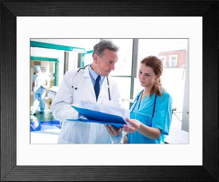 Framed Print : Doctor and nurse checking medical report