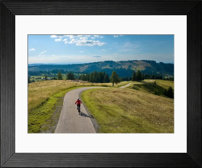 Framed Print : aerial view of a pretty mid age woman riding her electric mountain bike in the Allgau mountains near Framed Print : aerial view of a pretty mid age woman riding her electric mountain bike in the Allgau mountains near
