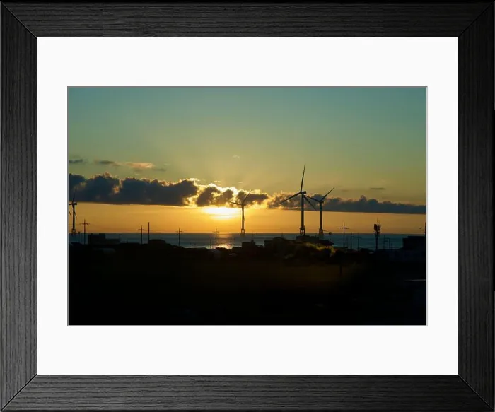Framed Print : Sunset light breaks beneath cloud bands behind offshore wind turbines and utility poles along Jeju's northwest shore Framed Print : Sunset light breaks beneath cloud bands behind offshore wind turbines and utility poles along Jeju's northwest shore