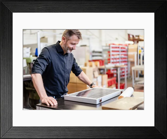 Framed Print : Man in factory working on solar cell Framed Print : Man in factory working on solar cell