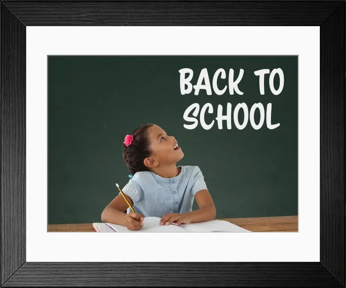Framed Print : Digital composite of Student girl at table looking up against green blackboard with back to school text Framed Print : Digital composite of Student girl at table looking up against green blackboard with back to school text