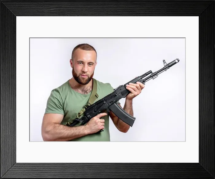 Framed Print : Strong caucasian shooter in casual clothing with sniper rifle looking at camera isolated on white