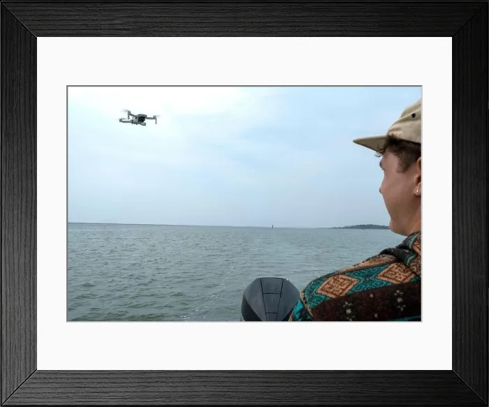 Framed Print : Young man operating aerial photography drone on a small boat Framed Print : Young man operating aerial photography drone on a small boat