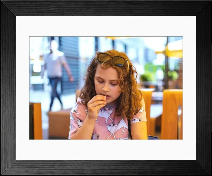 Framed Print : Child girl enjoying french fries Framed Print : Child girl enjoying french fries