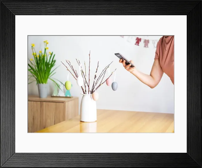 Framed Print : Female hand making photo with smartphone from bouquet with willow branches and colorful Easter eggs Framed Print : Female hand making photo with smartphone from bouquet with willow branches and colorful Easter eggs
