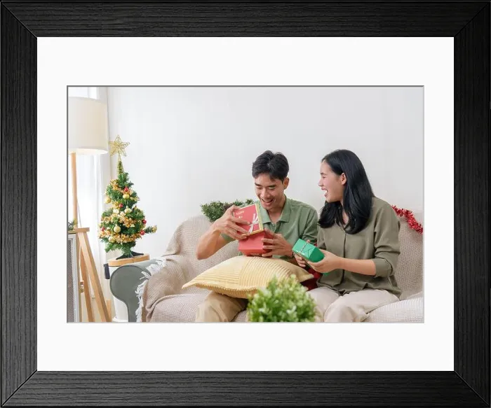 Framed Print : Christmas morning joy, happy couple shares deep love, exchanging holiday gifts together at cozy home Framed Print : Christmas morning joy, happy couple shares deep love, exchanging holiday gifts together at cozy home