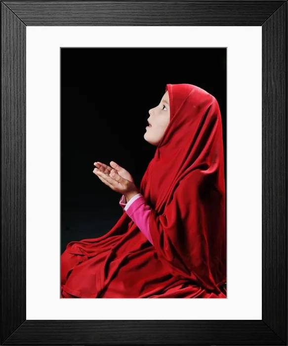 Framed Print : Beautiful young muslim girl praying on black background Framed Print : Beautiful young muslim girl praying on black background