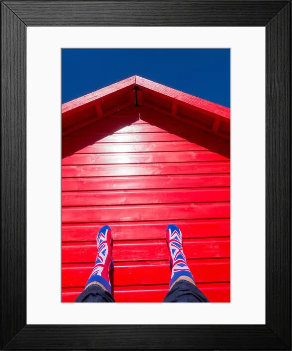 Framed Print : Man wearin Union Jack socks resting against red beach hut on a hot day at the beach. uk Framed Print : Man wearin Union Jack socks resting against red beach hut on a hot day at the beach. uk