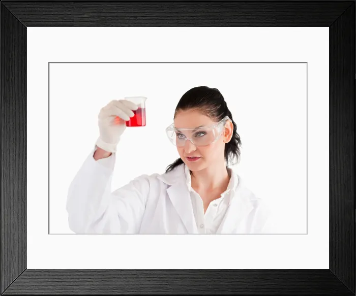 Framed Print : Dark-haired woman looking at a red beaker Framed Print : Dark-haired woman looking at a red beaker
