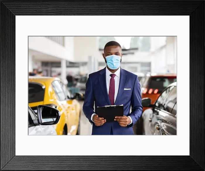 Framed Print : Young Black Car Salesman Wearing Medical Mask Posing At Workplace In Showroom Framed Print : Young Black Car Salesman Wearing Medical Mask Posing At Workplace In Showroom